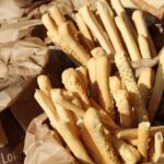 Immagine di grissini di diverse marche con etichette evidenziate, analisi delle peggiori scelte al supermercato.